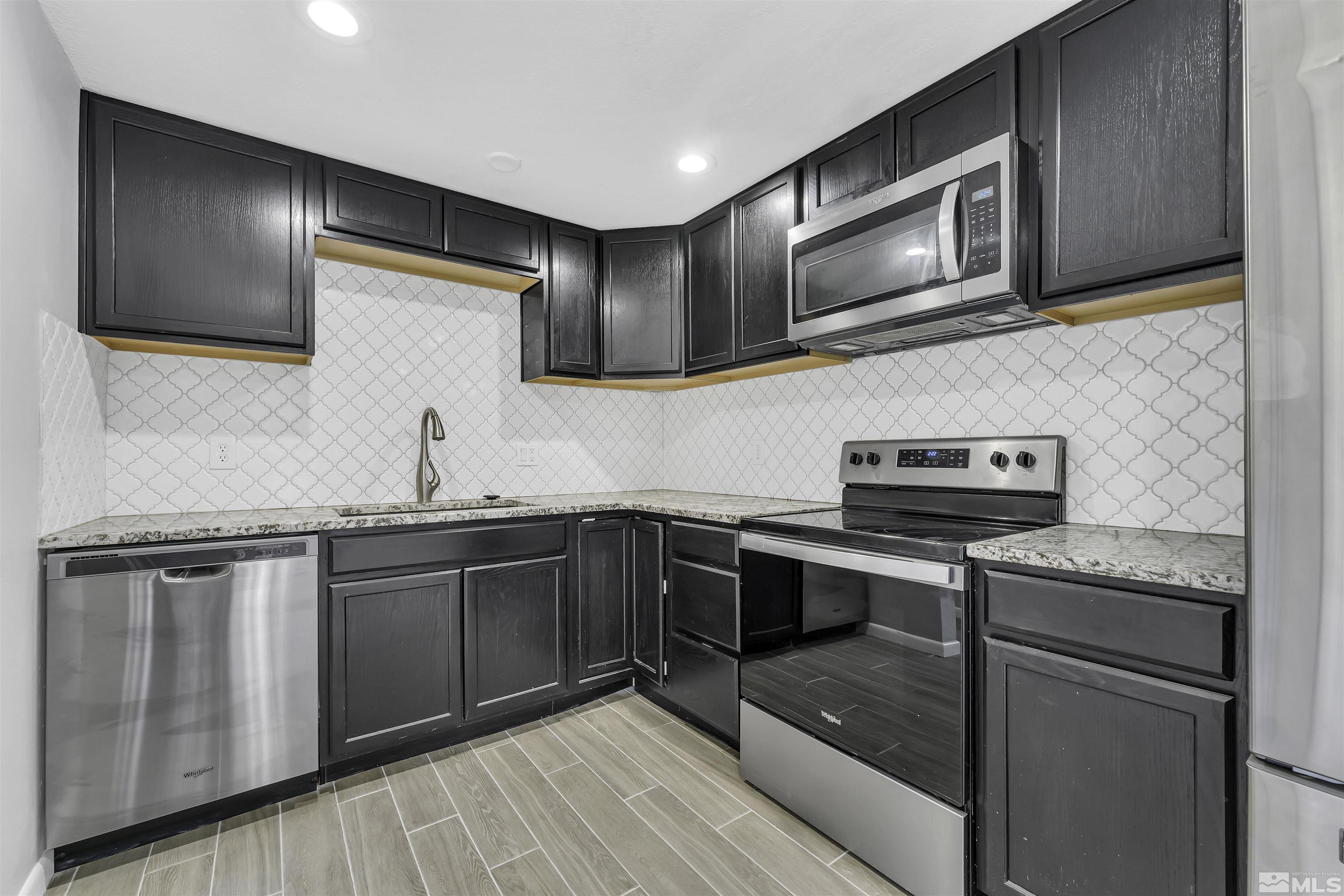 8625 Channel Way Reno, NV 89506 - Photo 8 of 29 a kitchen with stainless steel appliances granite countertop a sink stove and microwave