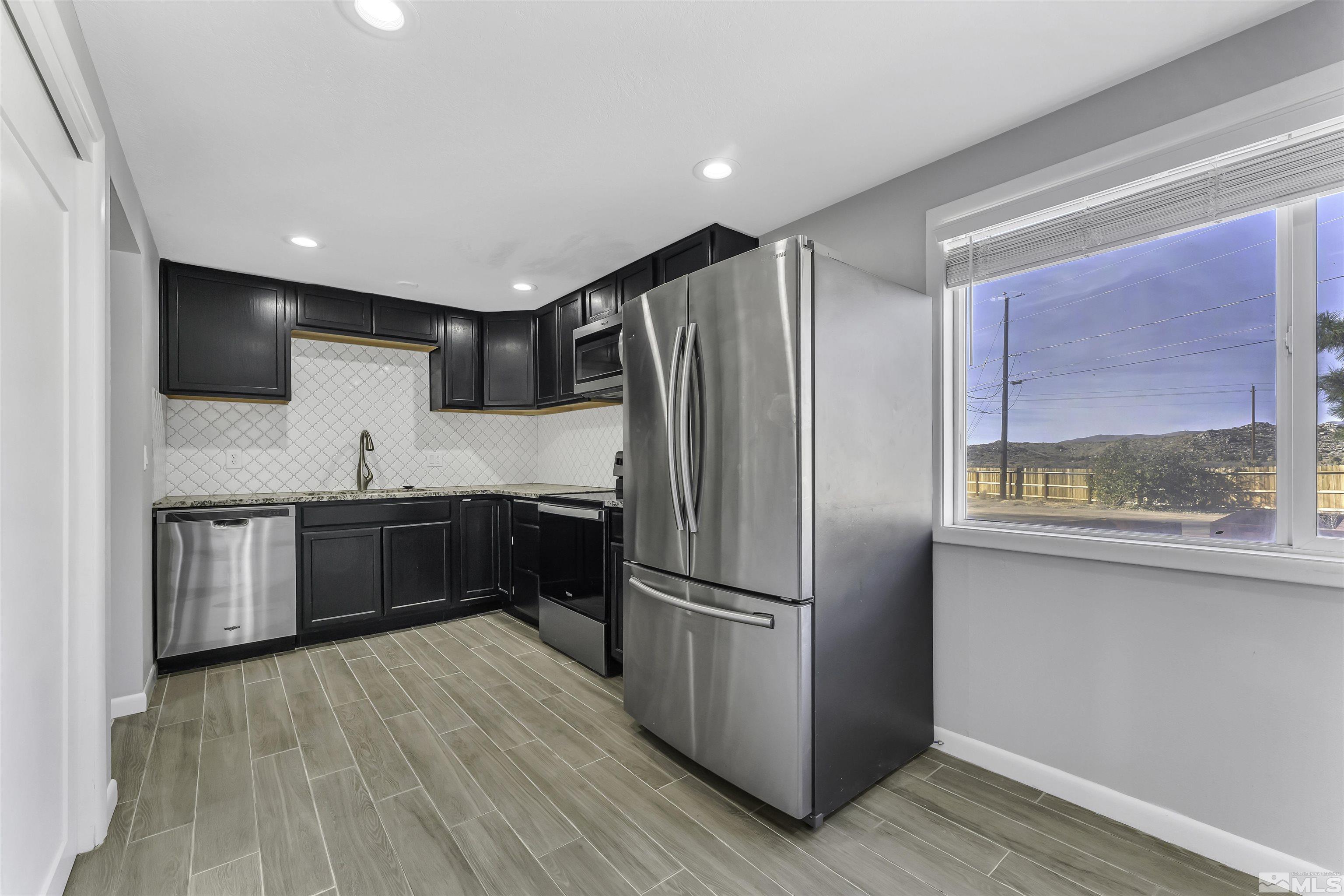 8625 Channel Way Reno, NV 89506 - Photo 10 of 29 a kitchen with a refrigerator a sink and cabinets
