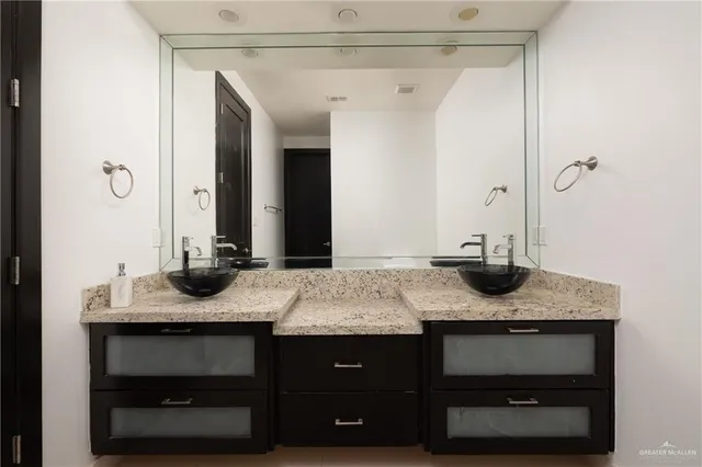 a bathroom with a granite countertop sink and a mirror