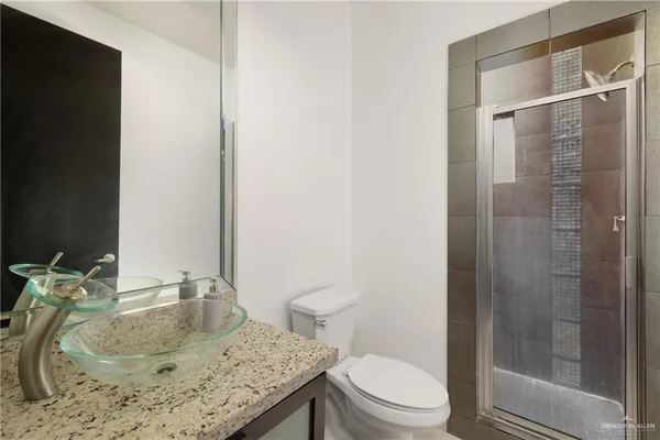 a bathroom with a granite countertop sink toilet and shower