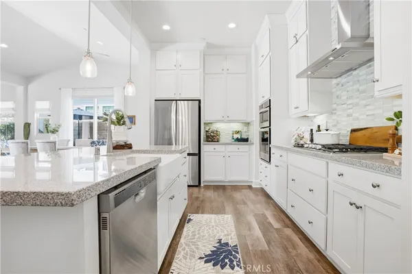 a kitchen with stainless steel appliances granite countertop a sink refrigerator and cabinets