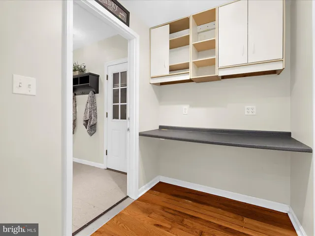 a view of a kitchen with white cabinets and a wooden floor