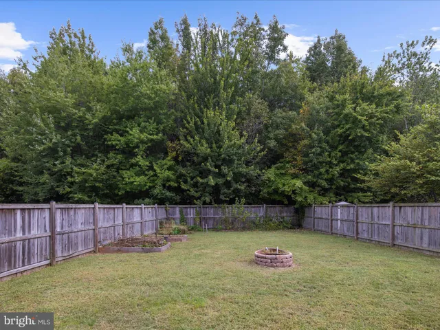 a backyard of apartments with large trees and wooden fence