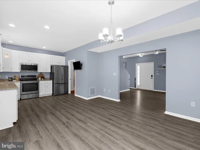 a view of a kitchen with stove and wooden floor