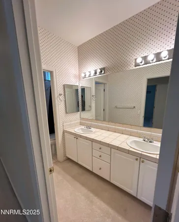 a bathroom with a double vanity sink and a mirror
