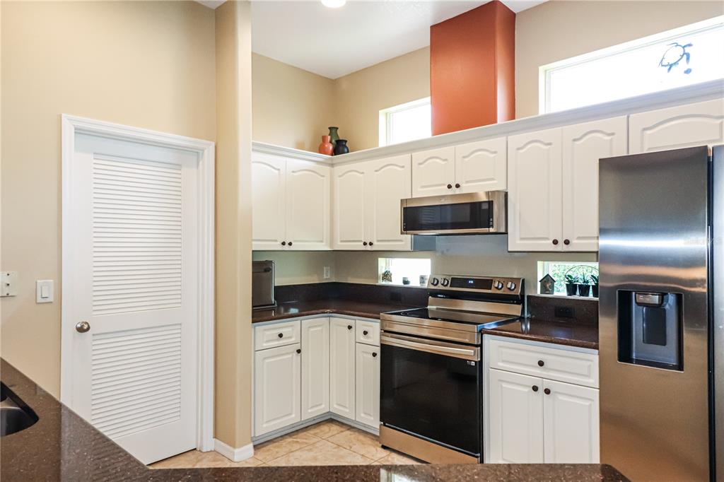 27328 Pine Straw Road Leesburg, FL 34748 - Photo 11 of 32 a kitchen with stainless steel appliances white cabinets and a sink