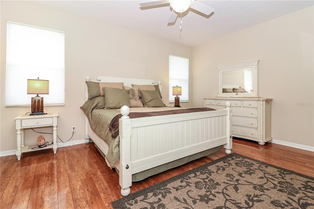 27328 Pine Straw Road Leesburg, FL 34748 - Photo 14 of 32 a bedroom with a bed and a chandelier