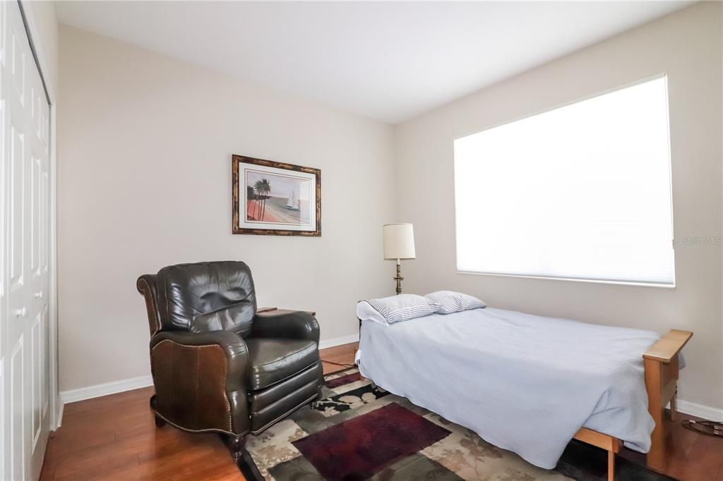 27328 Pine Straw Road Leesburg, FL 34748 - Photo 18 of 32 a bedroom with a bed and a chair