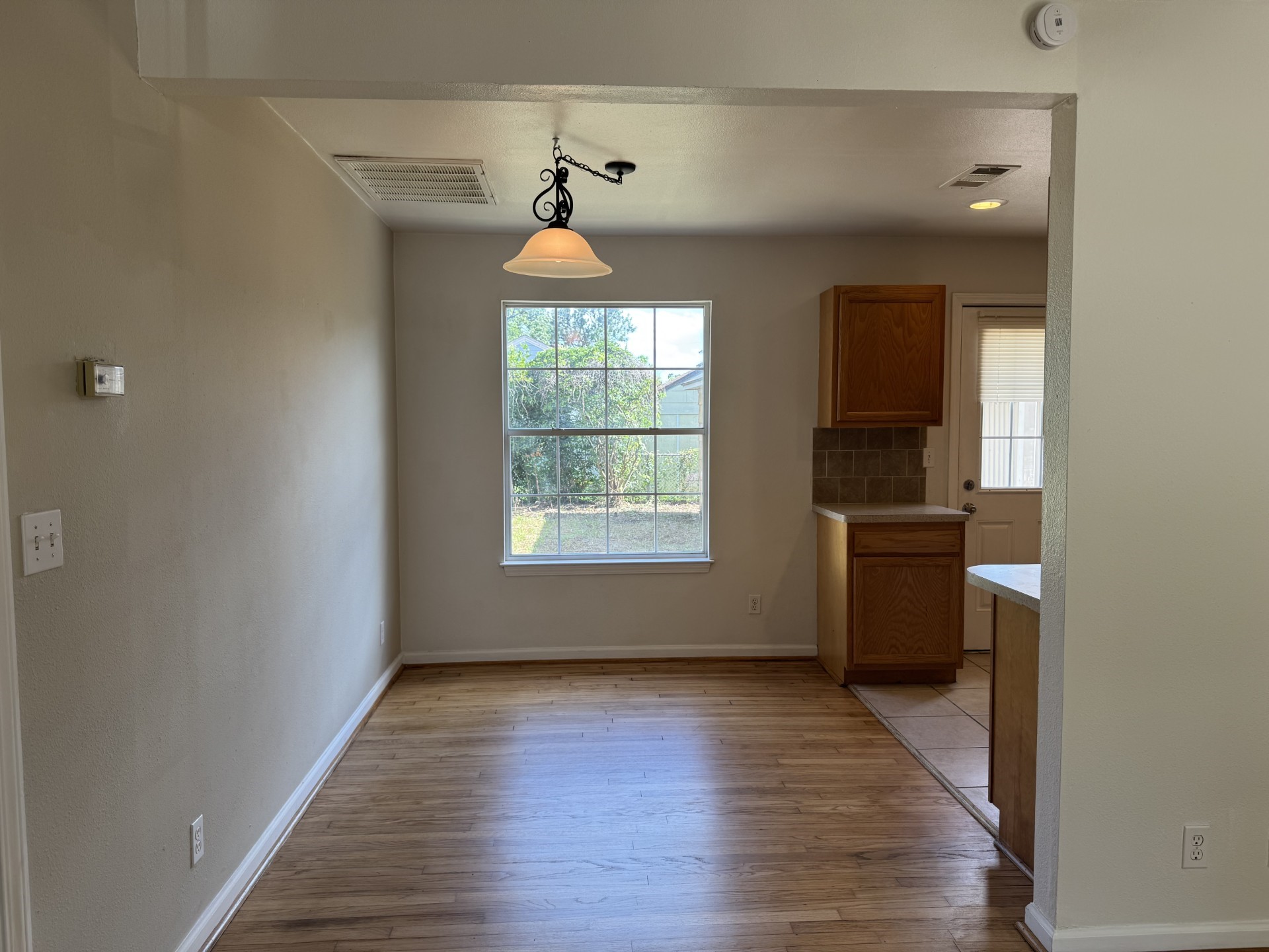 216 Gale Street Houston, TX 77009 - Photo 6 of 12 an empty room with wooden floor a ceiling fan and a window