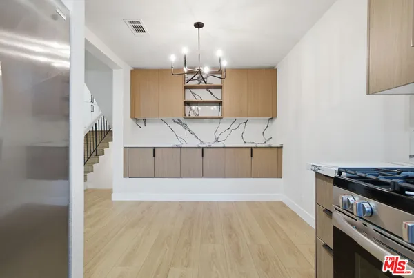 a kitchen with kitchen island a counter top space cabinets and stainless steel appliances