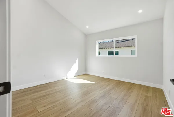 an empty room with wooden floor and entrance