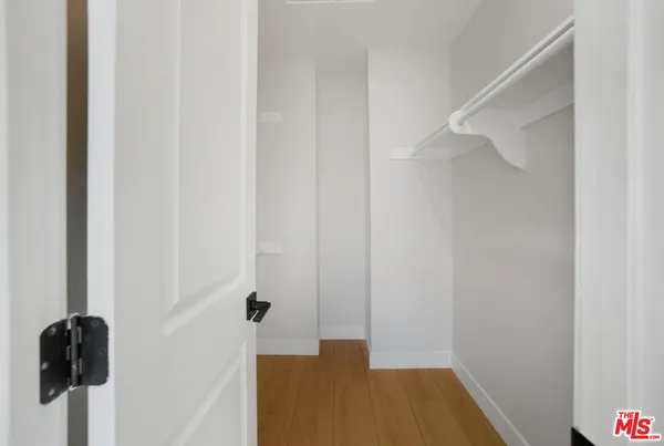 a view of a big room with wooden floor and windows