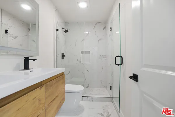 a bathroom with a sink a toilet and shower