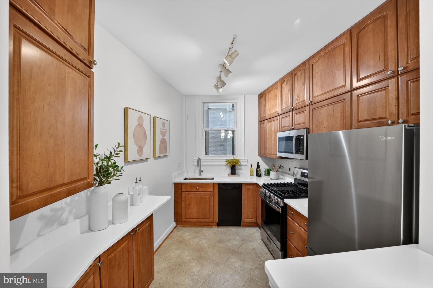 2126 Connecticut Avenue Northwest, Unit 17 Washington, DC 20008 - Photo 12 of 36 a kitchen with stainless steel appliances granite countertop a refrigerator a stove a sink dishwasher and wooden cabinets with wooden floor