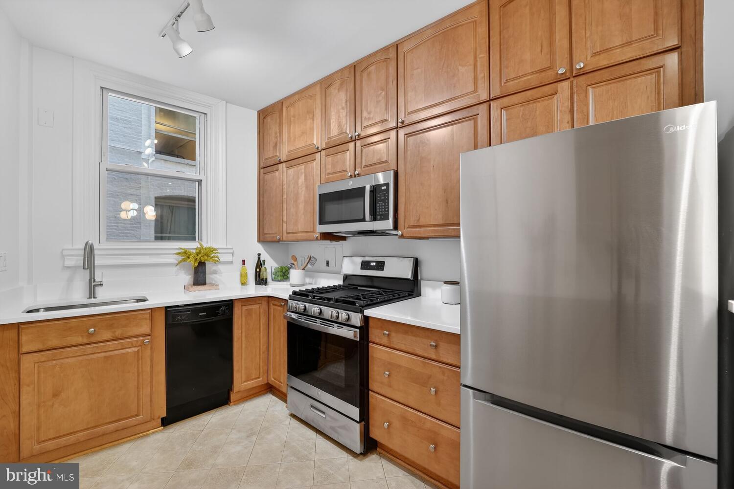 2126 Connecticut Avenue Northwest, Unit 17 Washington, DC 20008 - Photo 13 of 36 a kitchen with stainless steel appliances granite countertop a refrigerator stove a sink dishwasher and microwave