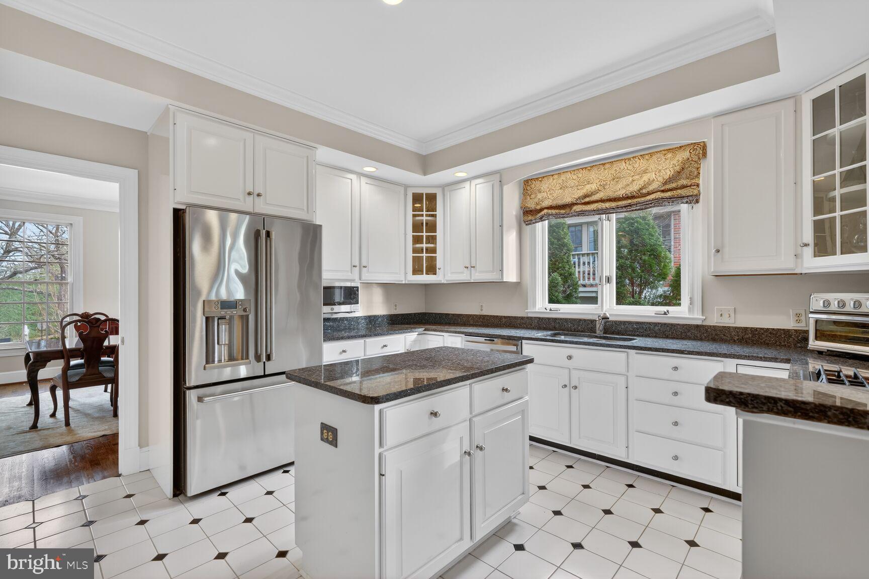 5206 Little Falls Road Arlington, VA 22207 - Photo 12 of 49 a kitchen with granite countertop a refrigerator sink and white cabinets