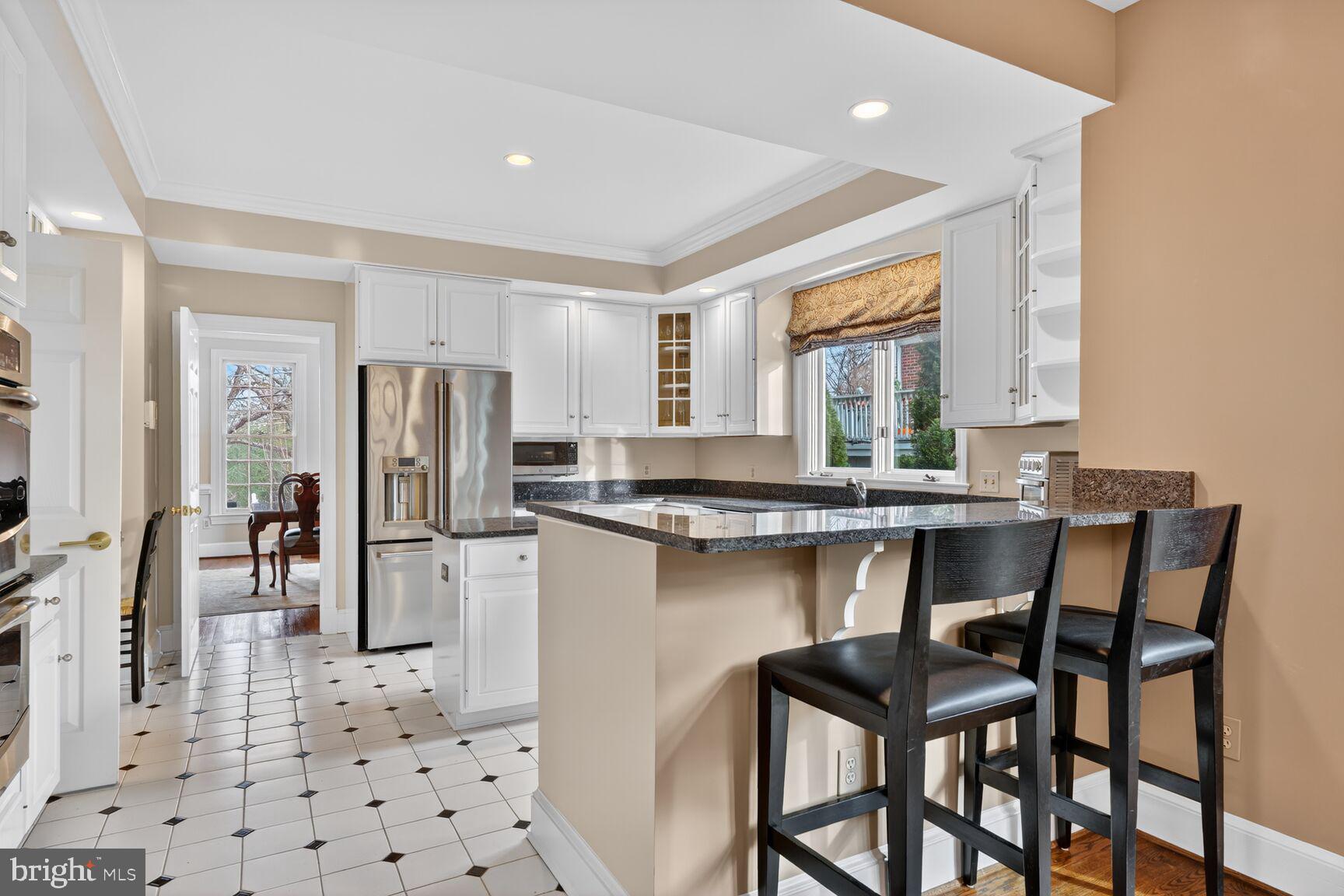 5206 Little Falls Road Arlington, VA 22207 - Photo 14 of 49 a kitchen with a table chairs refrigerator and microwave