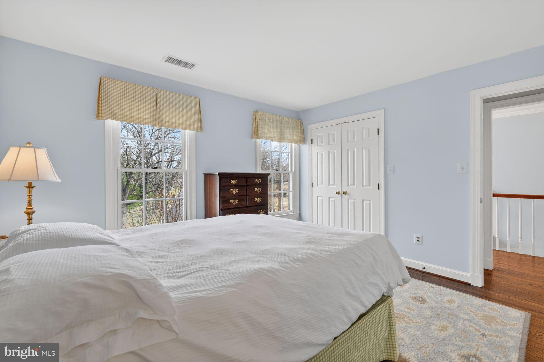 5206 Little Falls Road Arlington, VA 22207 - Photo 32 of 49 a spacious bedroom with a bed and a wooden floor