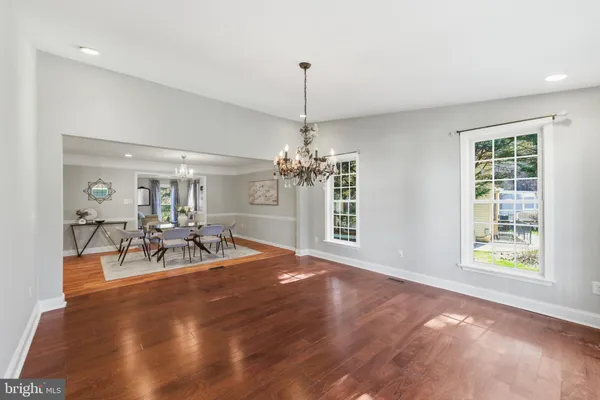 a view of a dining room with furniture a chandelier and wooden floor