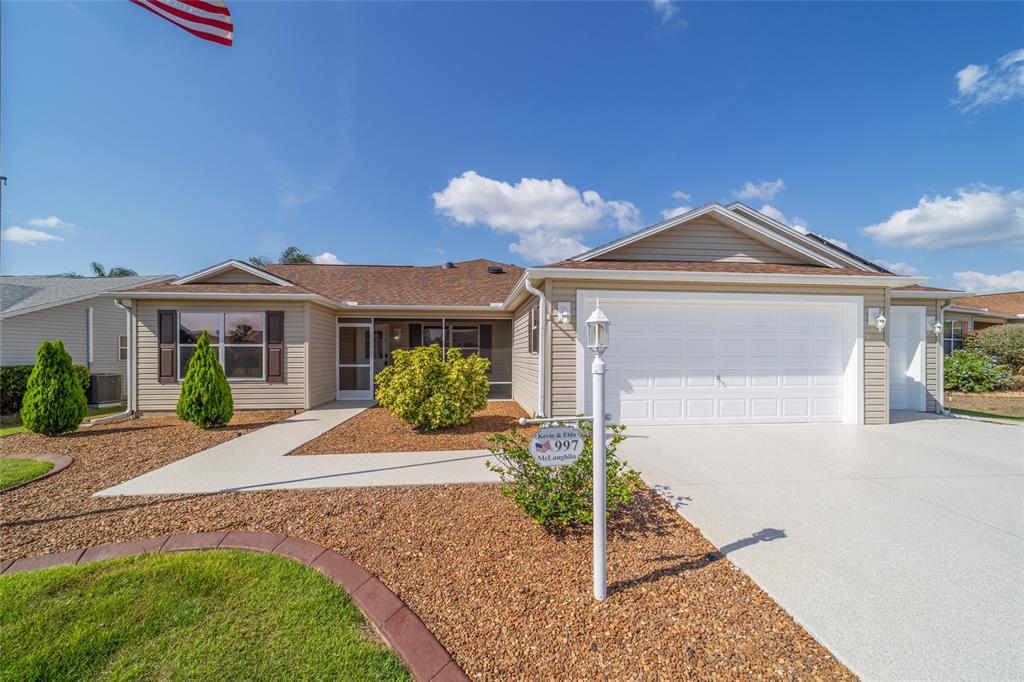 997 Nash Loop The Villages, FL 32162 - Photo 1 of 1 a front view of a house with a yard and potted plants