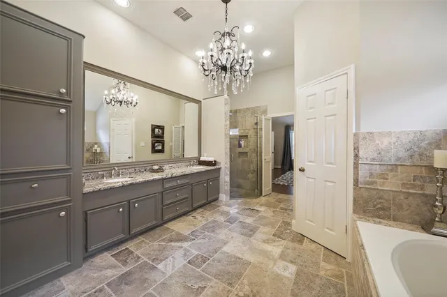 a large bathroom with a granite countertop tub sink shower and mirror