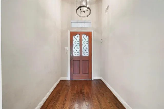a view of a hallway with wooden floor and a door
