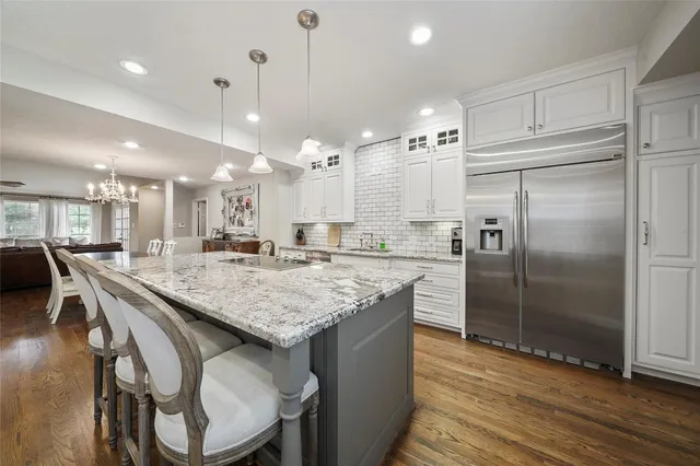 a kitchen with kitchen island a large counter top space appliances and cabinets