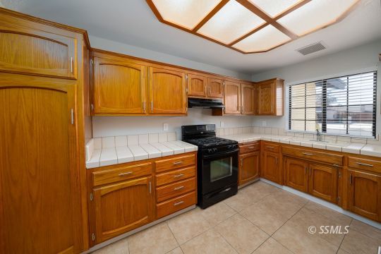 318 Reese Street Ridgecrest, CA 93555 - Photo 8 of 34 a kitchen with stainless steel appliances granite countertop a stove a sink and a microwave
