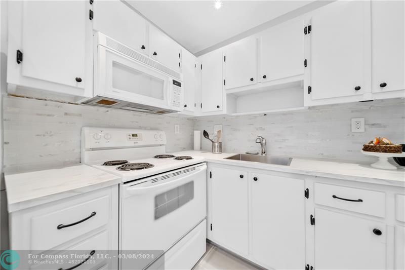a kitchen with cabinets appliances a sink and a counter top