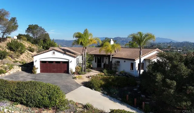 a front view of a house with a yard and mountain view