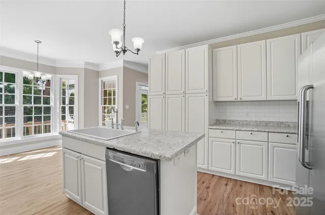 a kitchen with stainless steel appliances granite countertop a sink and dishwasher with wooden floor