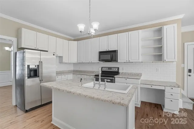 a kitchen with granite countertop a center island stainless steel appliances and cabinets