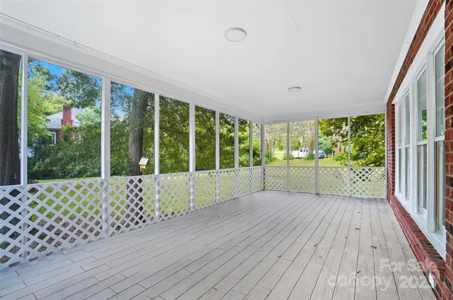 a view of an empty room with wooden floor and fence