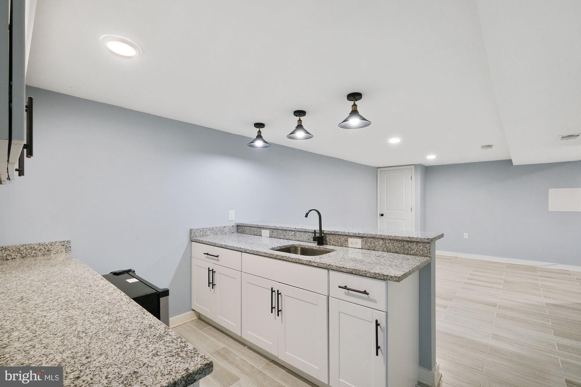 3158 M Place Southeast Washington, DC 20019 - Photo 9 of 22 a kitchen with a granite countertop sink and white cabinets