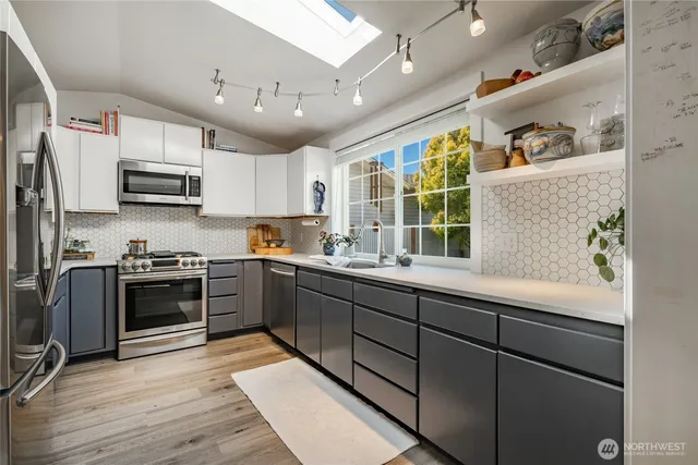 a kitchen with stainless steel appliances granite countertop a stove sink and microwave