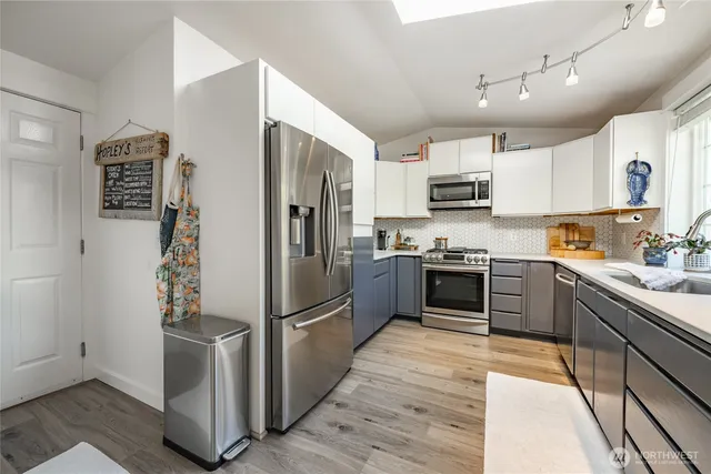 a kitchen with granite countertop a refrigerator and a stove top oven