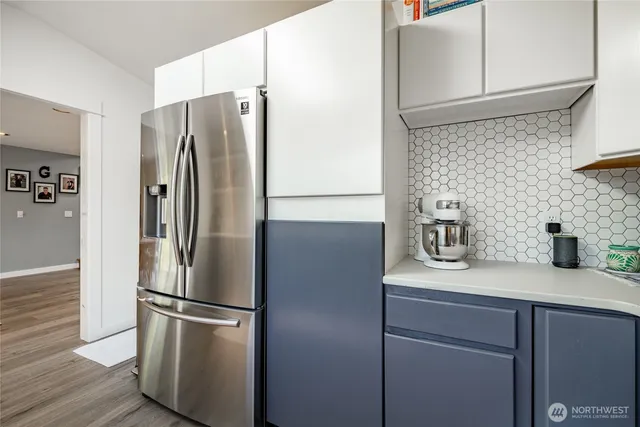 a metallic refrigerator freezer sitting in a kitchen