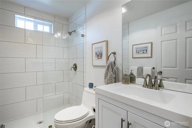 a bathroom with a sink a toilet and shower