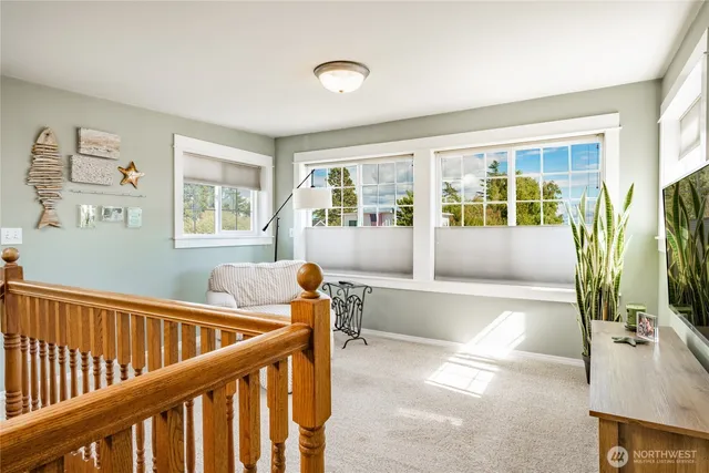 a view of a hallway with wooden floor and windows