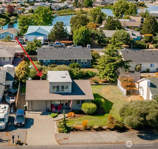 an aerial view of a house with a garden and lake view