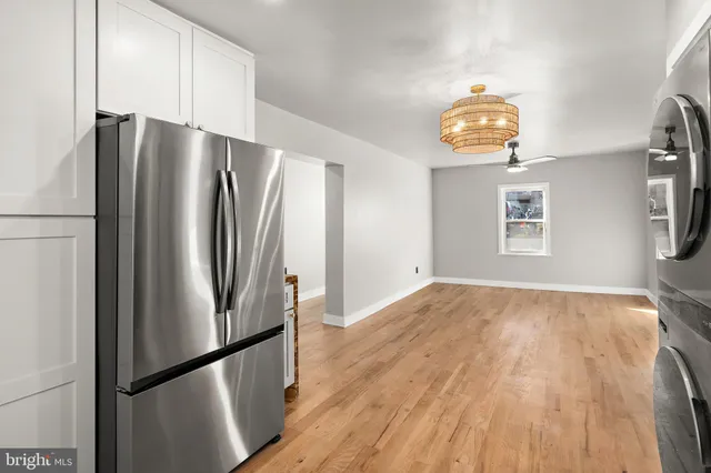 a view of a kitchen with a refrigerator and wooden floor