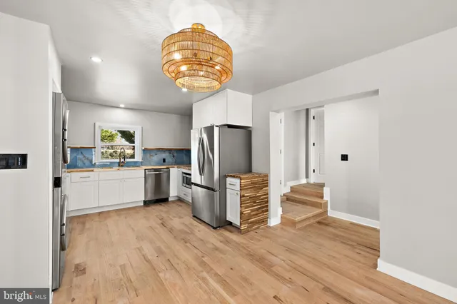 a kitchen with stainless steel appliances a refrigerator and a stove top oven
