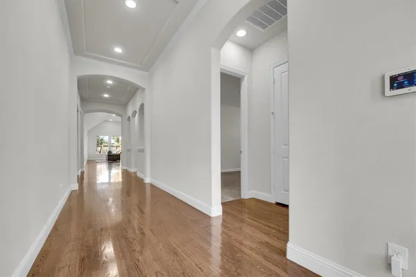 a view of a hallway with wooden floor and closet