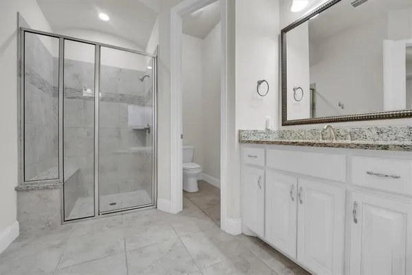 a spacious en suite bathroom with a granite countertop tub and a sink