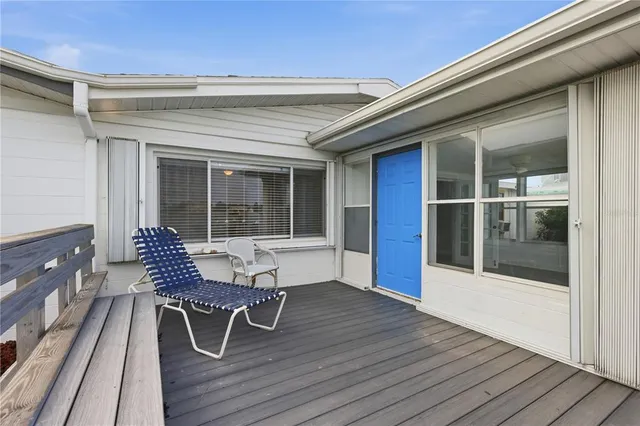 a view of a roof deck with table and chairs with wooden floor and fence