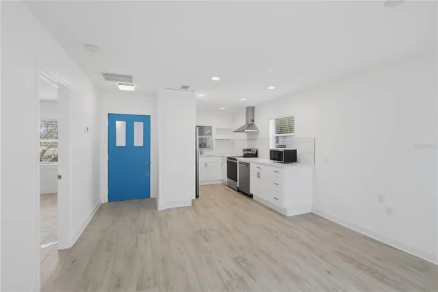a kitchen with a refrigerator and white cabinets