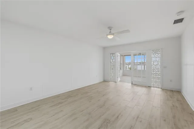 an empty room with wooden floor and windows