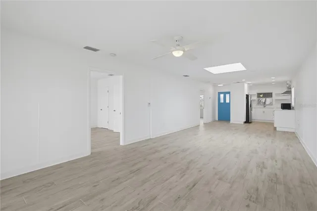 a view of a big room with wooden floor and windows