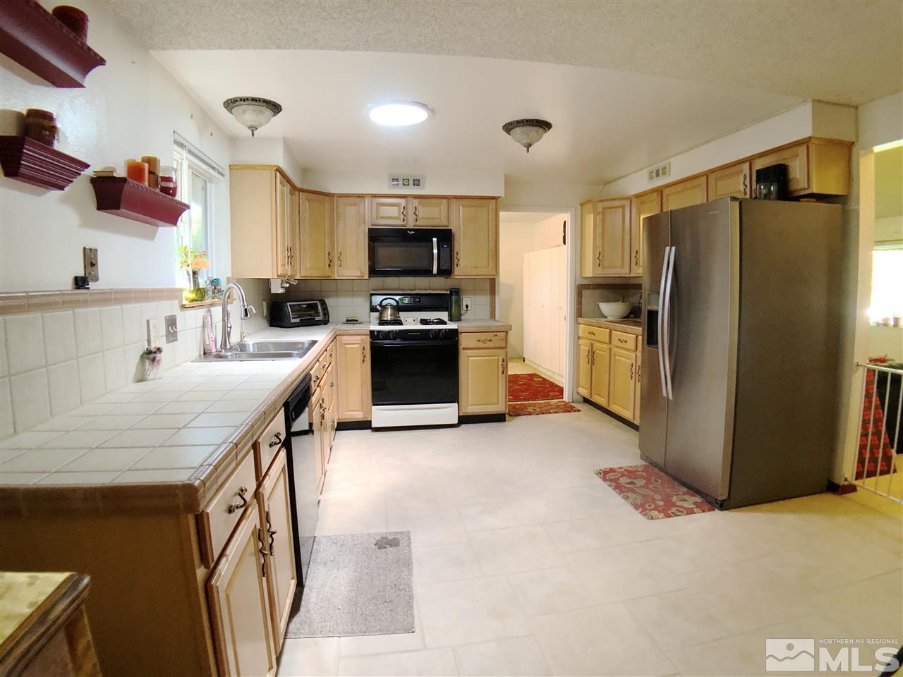 4210 Billy Drive Reno, NV 89502 - Photo 25 of 31 a kitchen with stainless steel appliances granite countertop a refrigerator a stove top oven a sink dishwasher and wooden cabinets