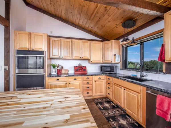 a living room with stainless steel appliances granite countertop furniture and wooden floors